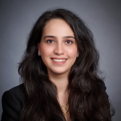 Studio portrait of Mahsa Adib facing the camera against a neutral gray background.